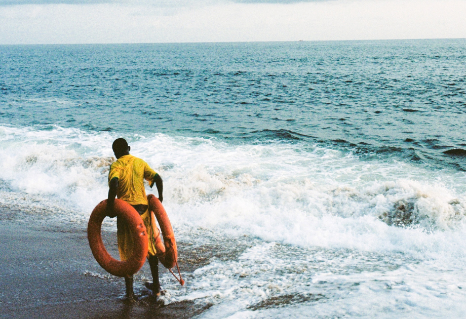 man on beach carrying life savers