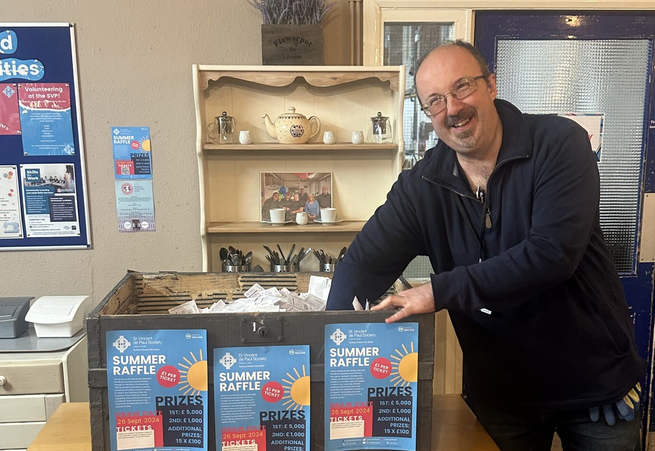 Image of man picking raffle ticket numbers out of a box