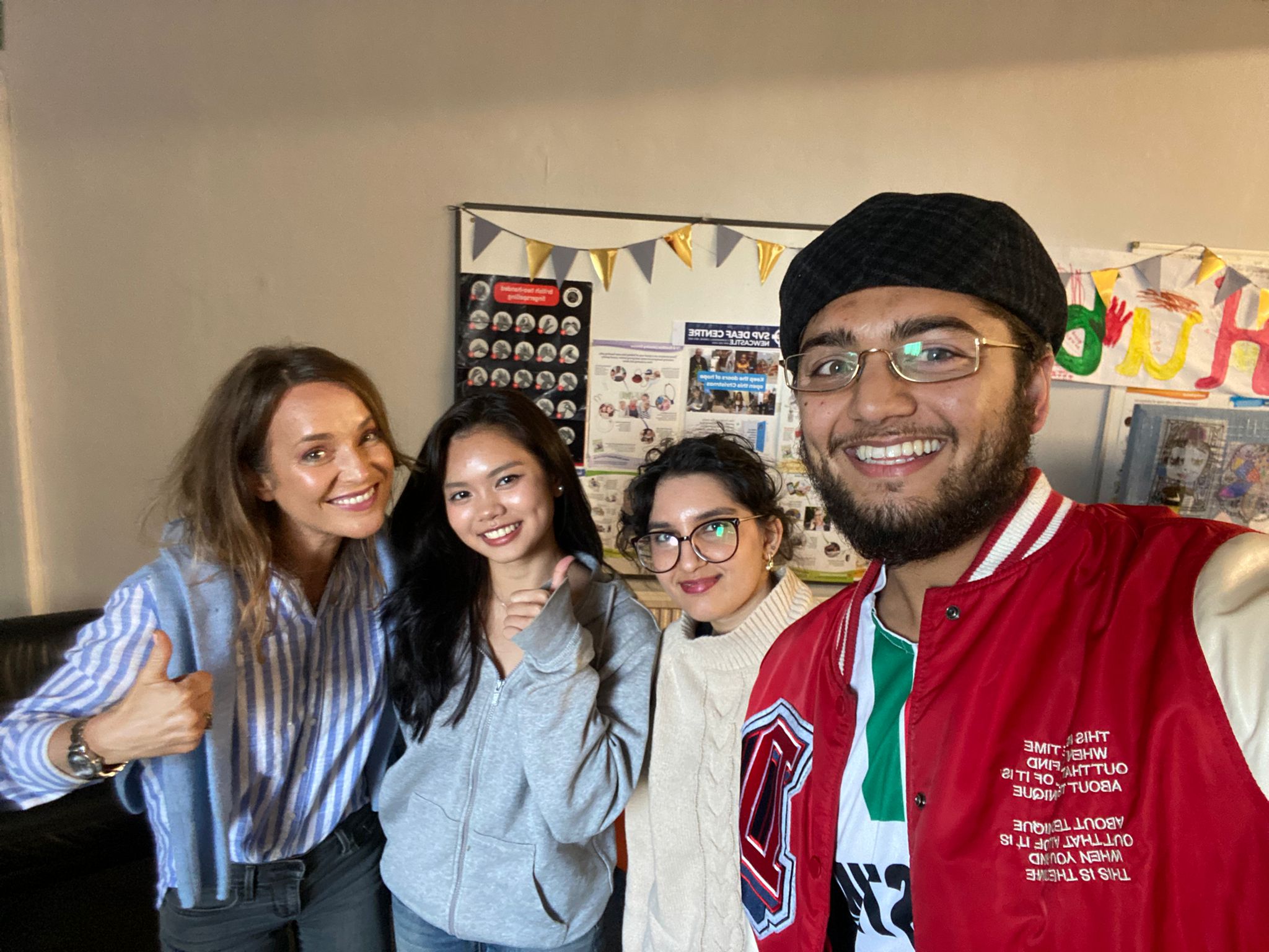 Group smiling taking selfie.