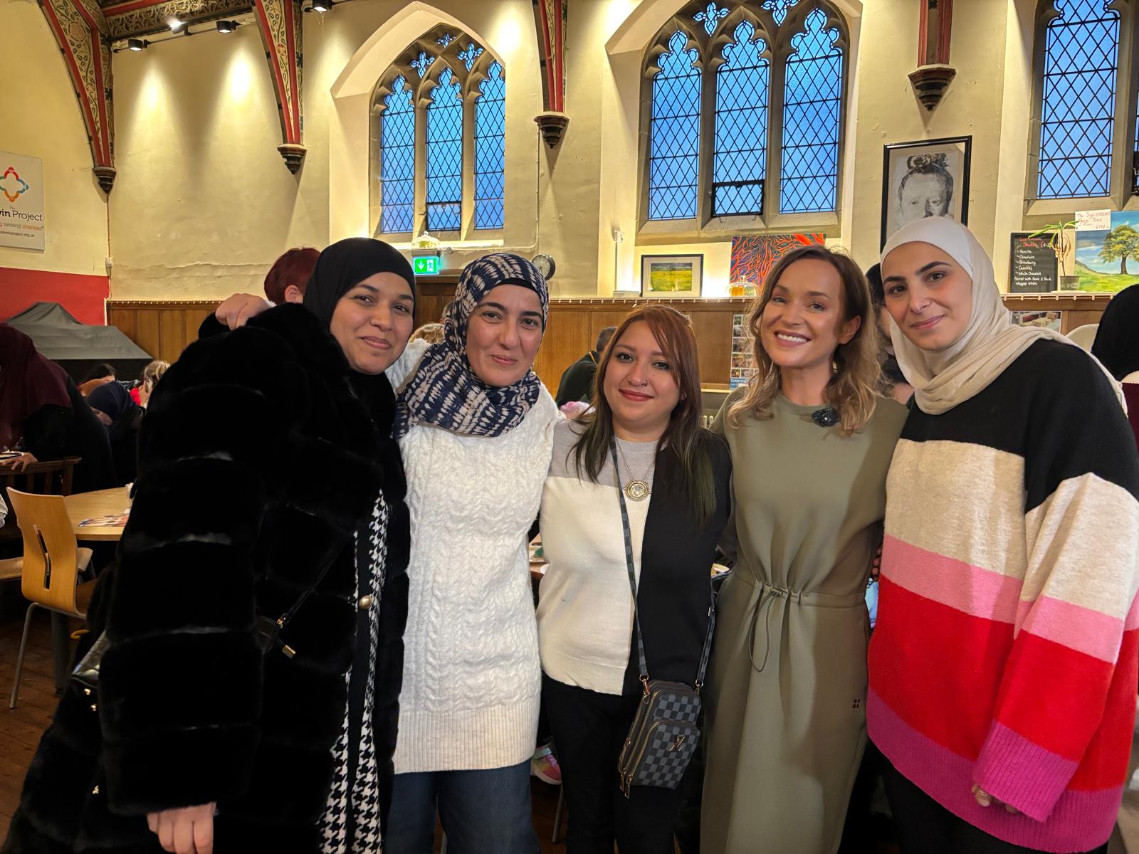 Women standing together smiling.