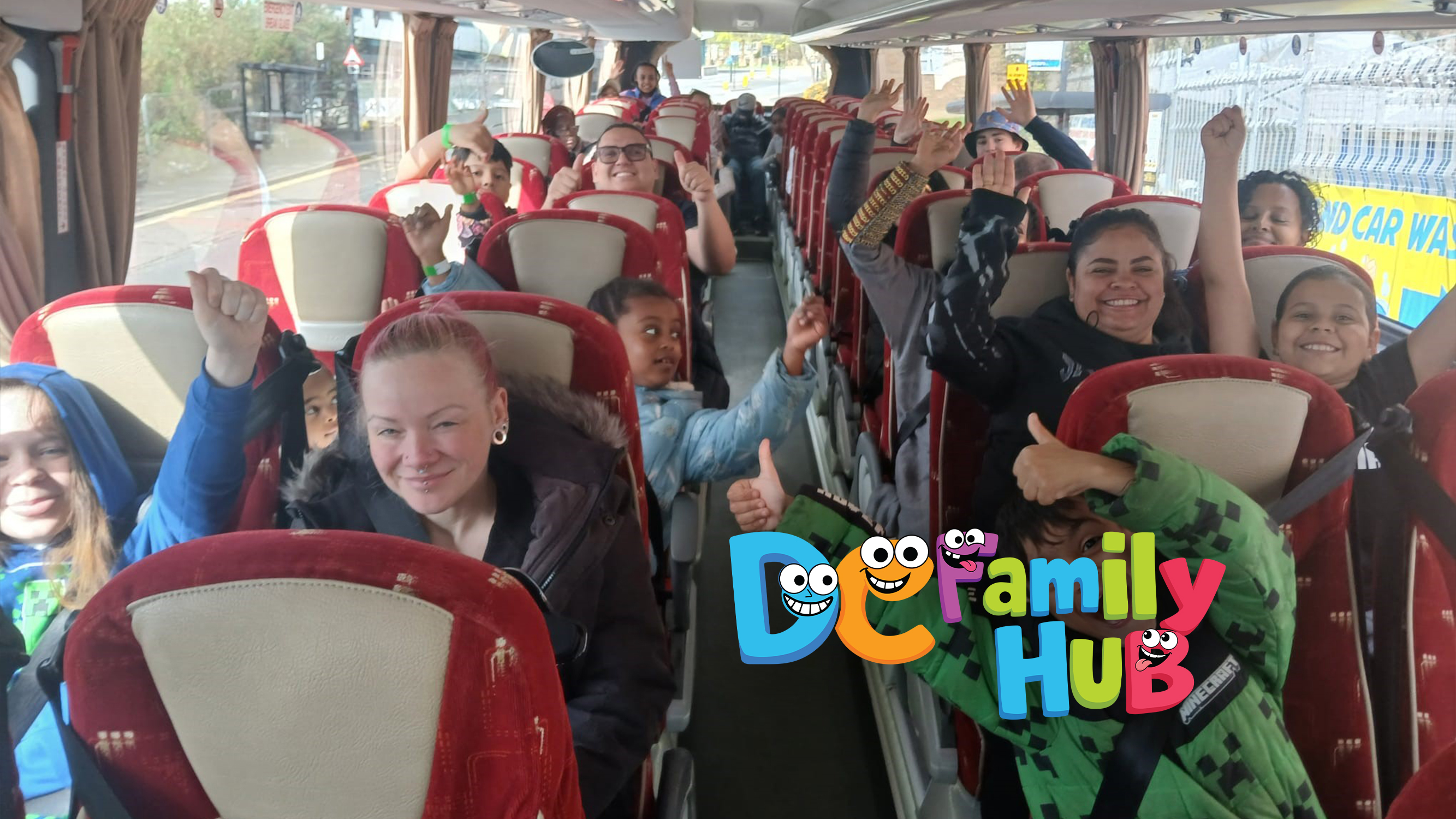 Kids and adults smiling on a bus.