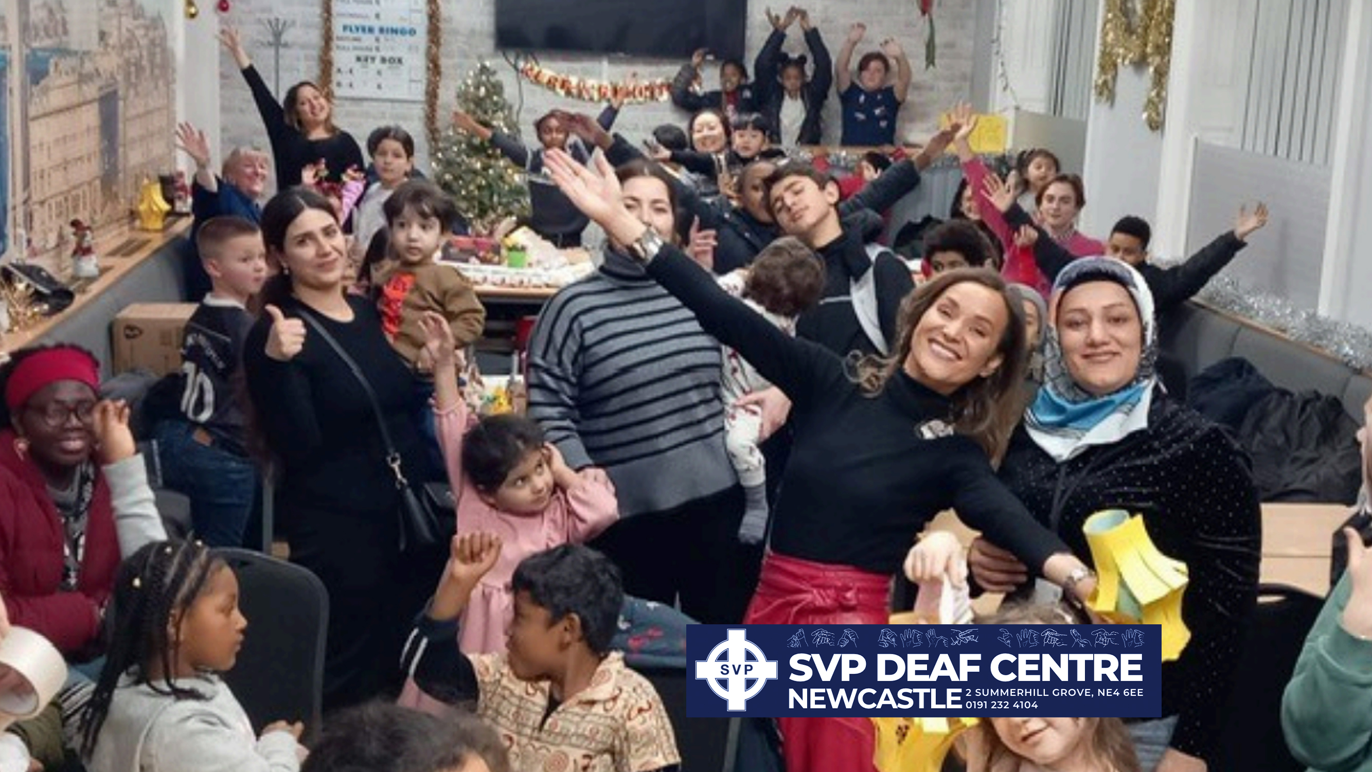 Group of people from the deaf centre smiling.